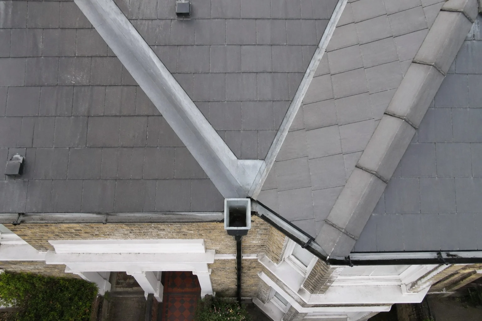 Roof valleys draining into a rainwater hopper and downpipe