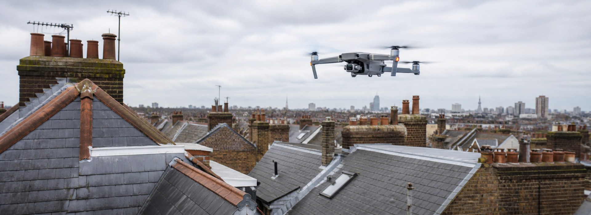 Illustrative drone flying above London residential roofs