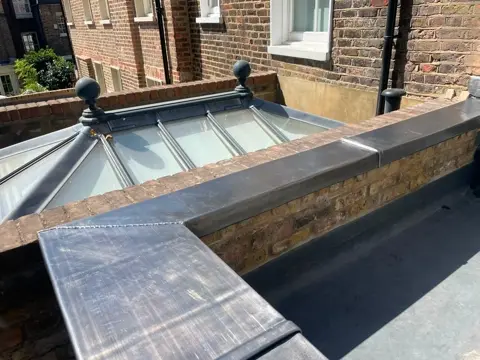 Wide view of completed lead capping to the parapet wall