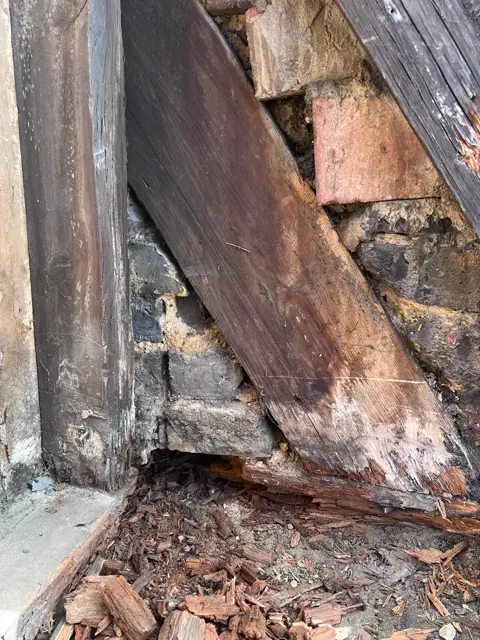 Exposed decayed timber within the church roof structure